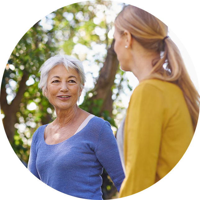 Two women near a tree.
