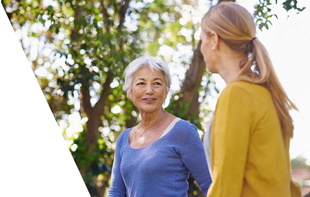 Two women near a tree.