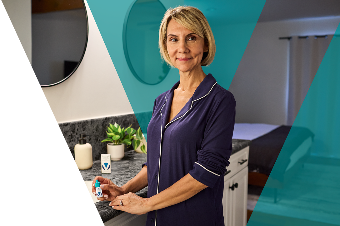 Woman in a bathroom holding a Vyzulta bottle.